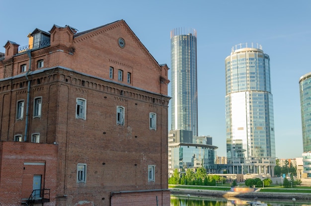 An old brick building against the background of modern houses.