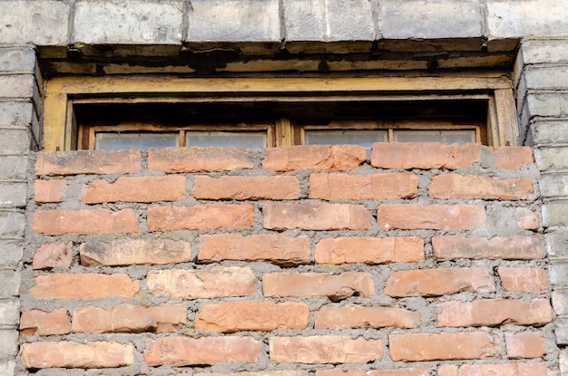 Photo old brick building nonresidential destroyed structure half of the window is covered with bricks inflation leads to poverty bad living conditions for people