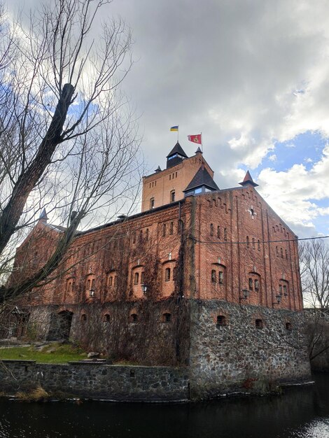 Старый кирпичный замок у реки в лесу