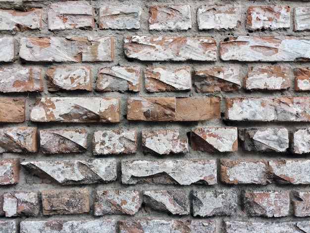 Old brick cracked wall with deep gaps between the blocks