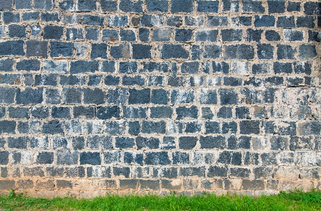 The old brick wall and green grass