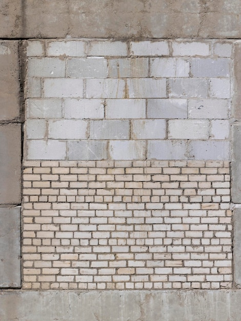 An old brick wall made of a large number of different types of bricks