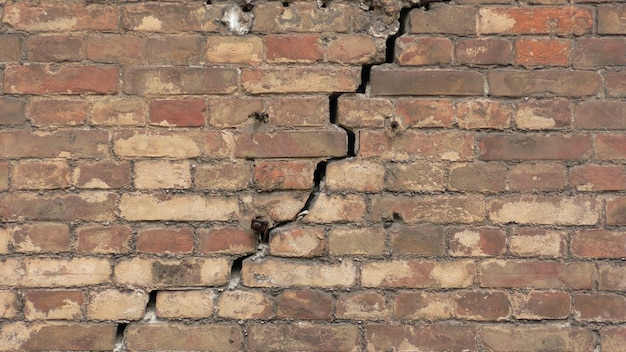 Foto vecchio muro di mattoni fatto di mattoni rossi crepa nel muro