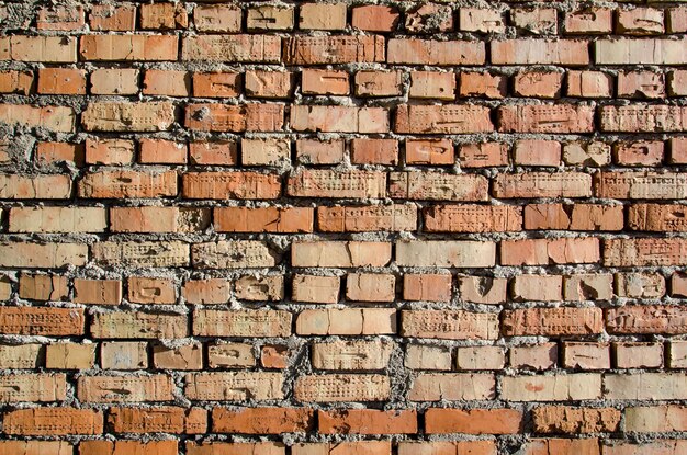 Old brick wall old texture of red and orange blocks of stone Closeup