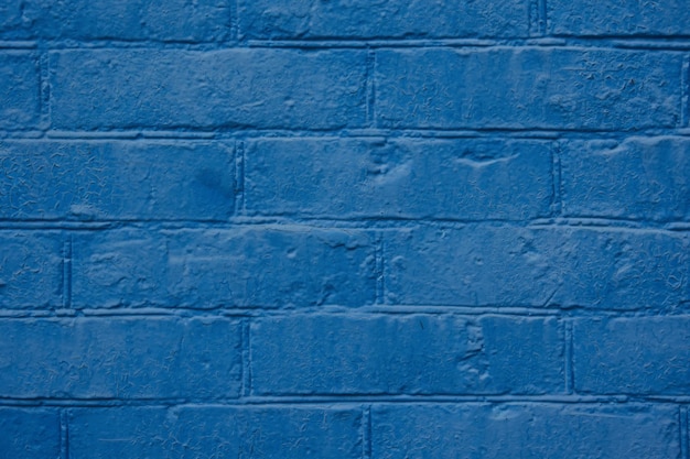 old brick wall painted with blue paint closeup