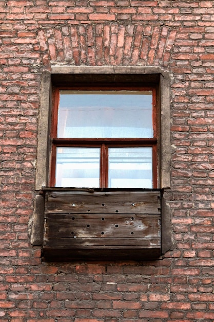 Old brick wall and window with wooden exterior fridge