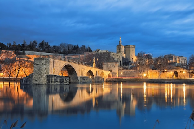 Old bridge and city skyline at dusk in Avignon France