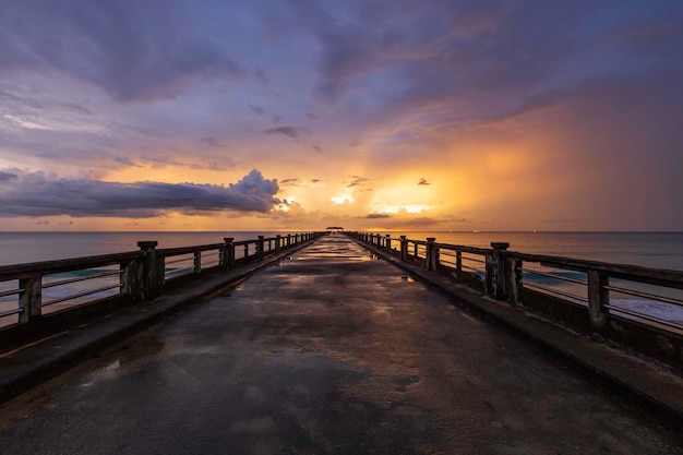 Old bridge pier against beautiful sunset sky after the rain