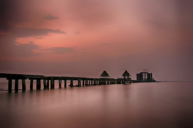 Old bridge in the sea on twilight time after sunset