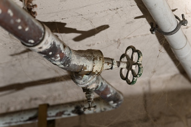 Old bronze water tap on the spider web