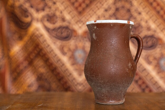 Foto retro vaso fatto a mano delle terraglie ceramiche della vecchia argilla marrone sulla tavola di legno