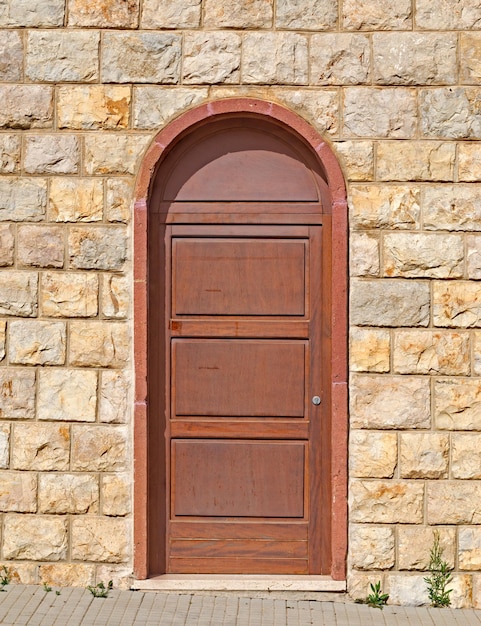 Old brown door in a brick wall