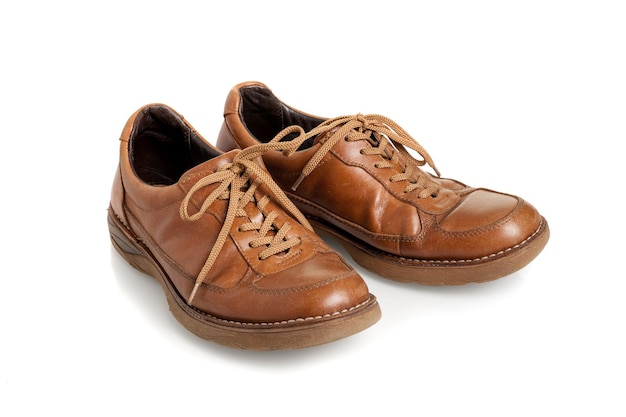 Old brown leather shoes for men over white background