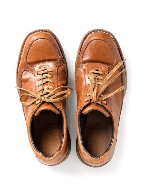 白い背景の上の男性のための古い茶色の革の靴