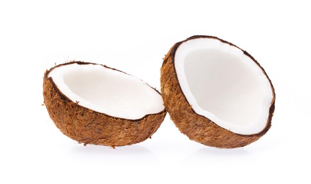 Old brown organic coconut fruit copra broken into pieces and stacked on white background