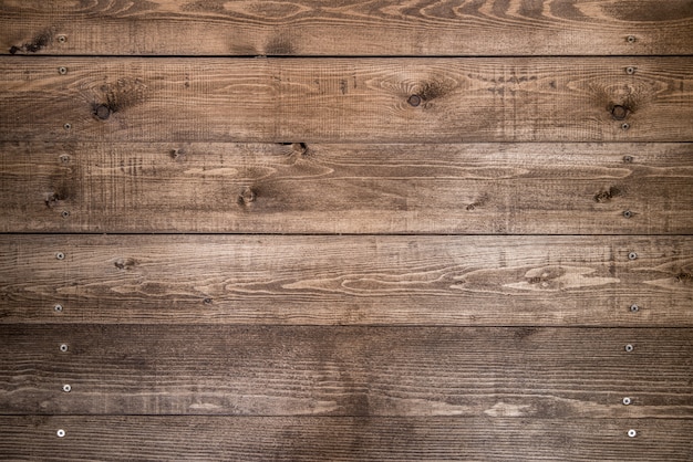 Old brown wood background made of dark natural wood in grunge style. Natural raw planed texture of pine. The surface of table to shoot flat lay. Copy space.