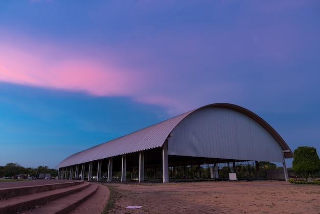 Старая строительная фабрика под сумеречным закатом фиолетового неба.