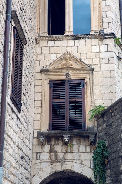 Old building in Montenegro with windows and shutters and ivy