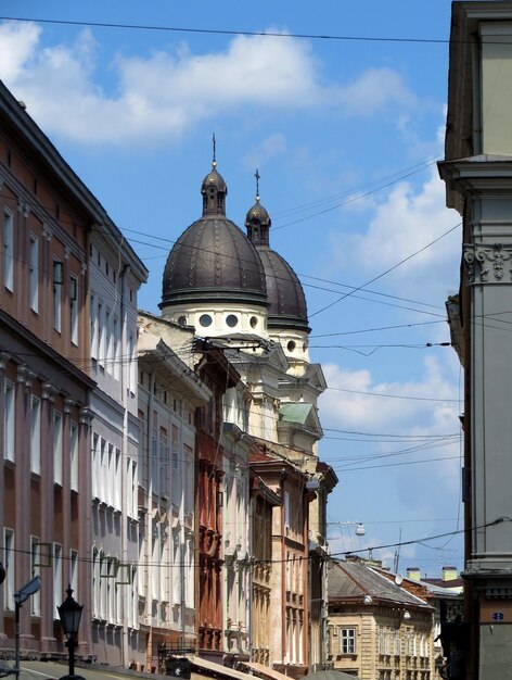 Old buildings of the street of a European city and the dome of the church on the background