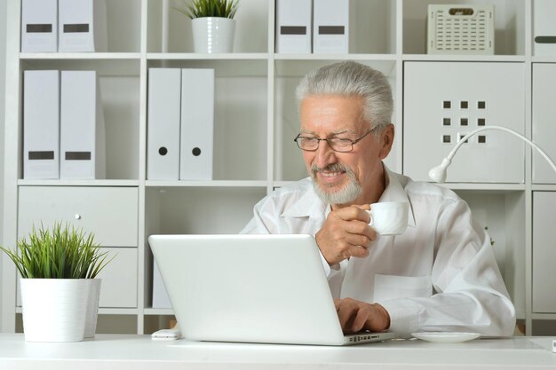 Old businessman with a laptop working