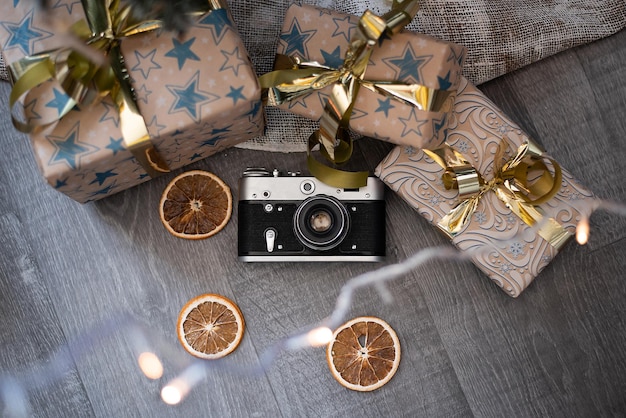 Foto una vecchia macchina fotografica giace accanto ai regali di natale e a un'arancia secca