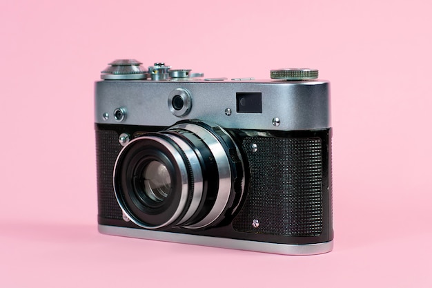 Old camera on a pink background