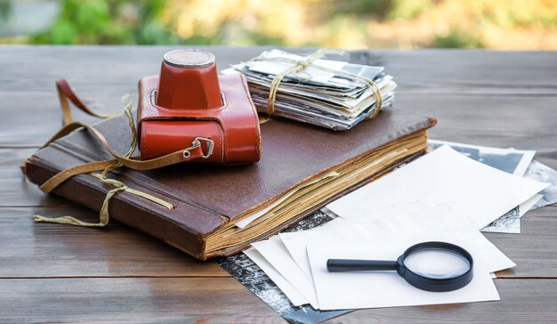 Old camera stack of photos and photo album on a wooden table