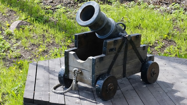 Vecchio cannone con ruote di legno nel parco estivo