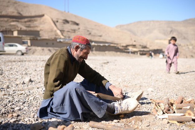 Photo an old carpenter cutting woods in village