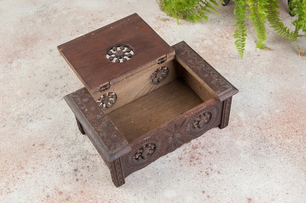 Old carved wooden box on concrete background. Copy space for text.
