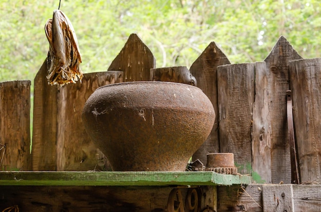 An old cast-iron cauldron on a shelf on the street.