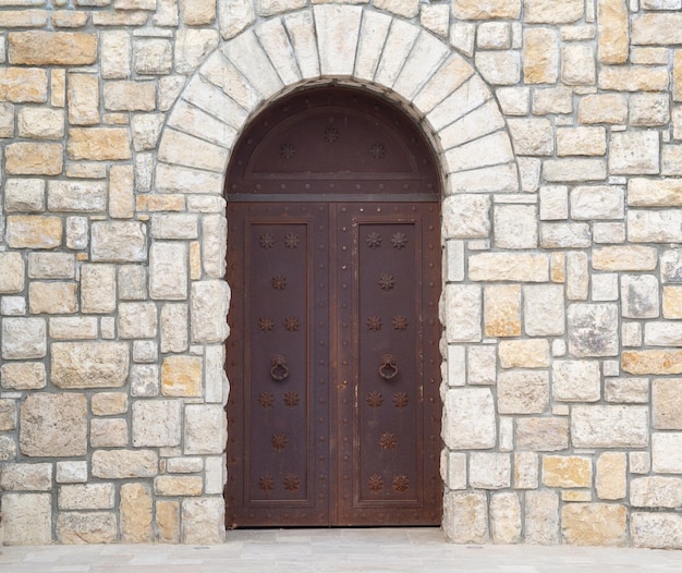 Foto vecchio muro di pietra del castello con grandi porte metalliche chiuse cancelli d'epoca porte retrò concetto antico