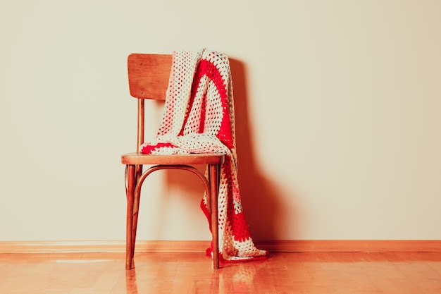 Old chair with carelessly abandoned blanket on it