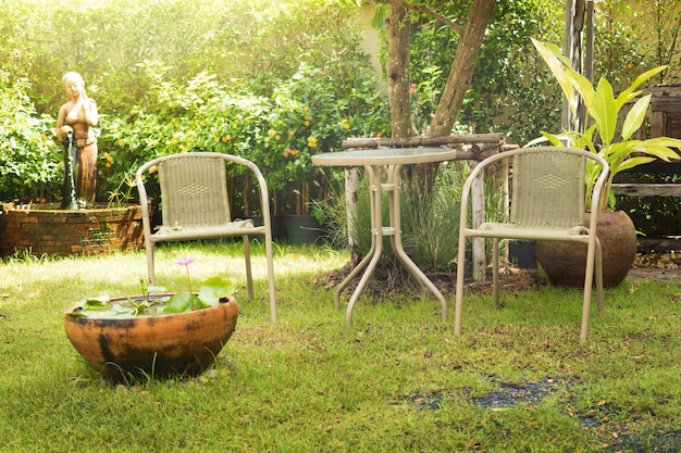 Photo old chairs in garden green bushes trees with clay flowers plant pots