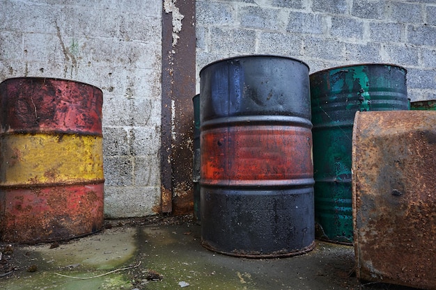 Old chemical barrels. blue, green red and rusty oil drum. steel\
oil tank. toxic waste warehouse. hazard chemical barrel