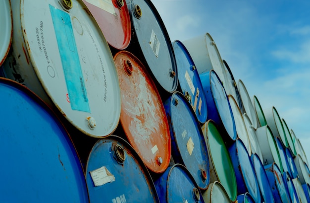 Old chemical barrels stack. Blue and red oil drum. Steel oil tank. Toxic waste warehouse. Hazard chemical barrel. Industrial waste in tank. Hazardous waste. Rusty oil drum stack. Brent crude oil.