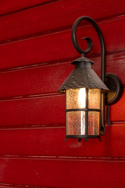 Фото Старый рождественский фонарь на деревянном стене фонарь улицы, украшенный на рождество горящий железный черный фонарй