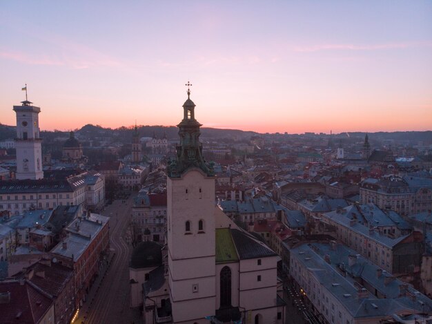 Old church tower with sunrise on background. european cityscape aerial view