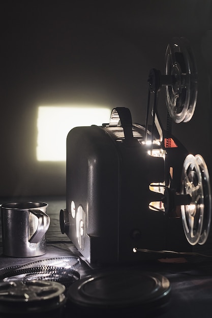 Photo old cinema projector and a glowing screen in the dark