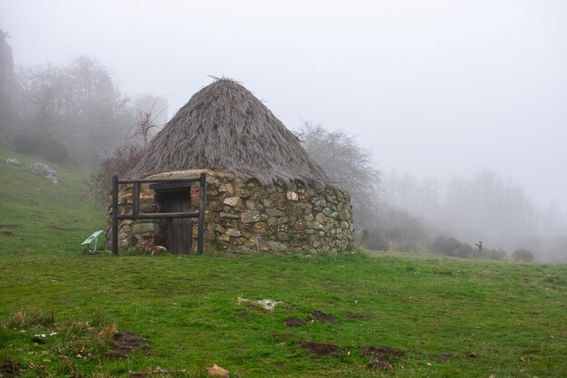 A old circular stone house with thatched roof in the mountains