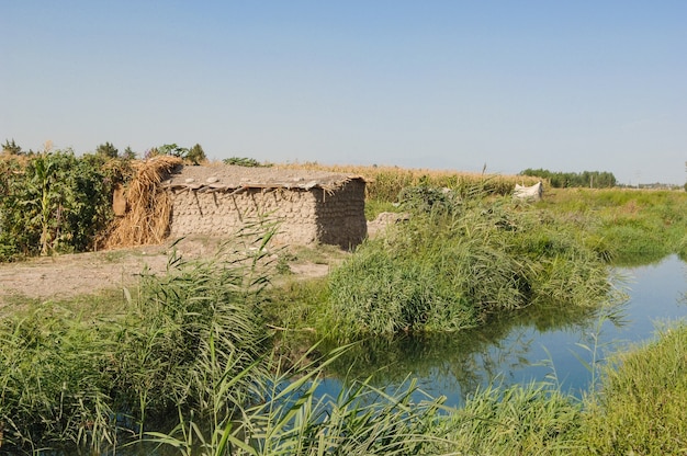 Old clay house near the river in the countryside. Nature of Central Asia