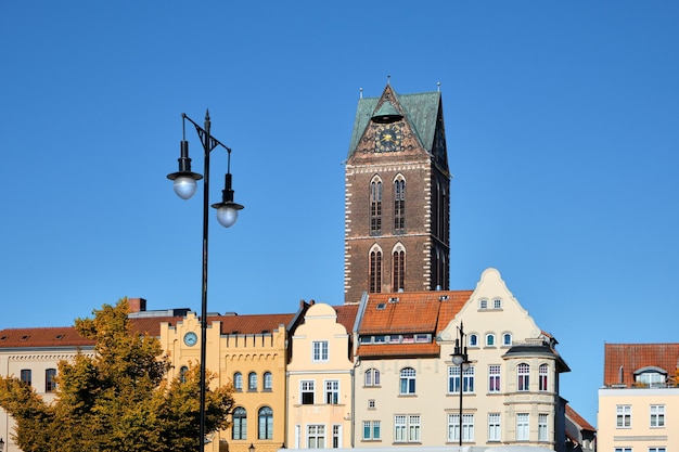 Old clock tower of Marienkirche church and historic buildings in center of Wismar Germany