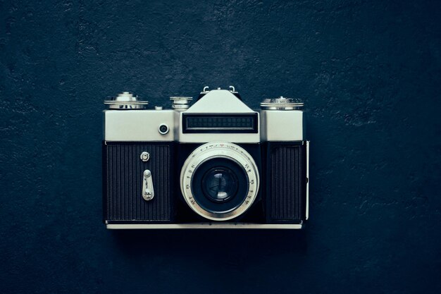 Old close up camera photo on dark background, vintage toning