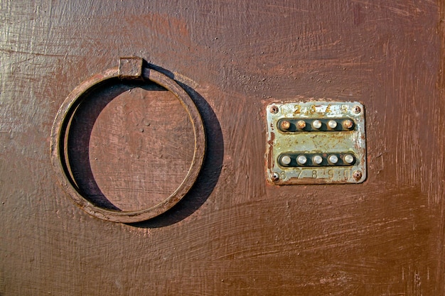 Old coded lock with round buttons on the iron door, close-up, old painted door, lock. Texture of paint on metal.