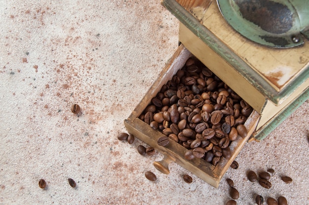 Old coffee grinder on concrete background. 