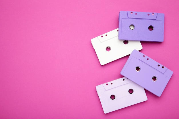 Old colorful cassettes on a pink background. Music day