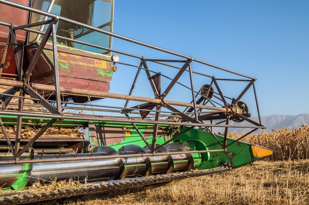 An old combine harvester works in the field Details of a working combine closeup