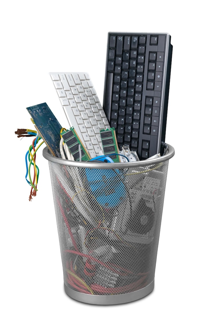 Photo old computer details in trashcan isolated on white background