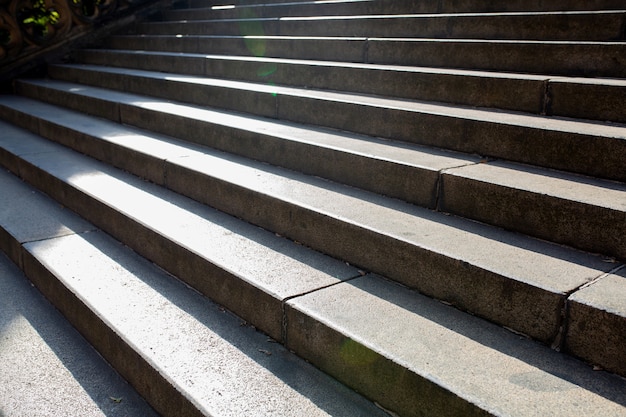 Old concrete staircase in front of the building with sun rays in Prague