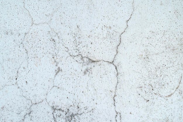 Old concrete stone wall covered with cracked plaster and dirty grunge textured surface